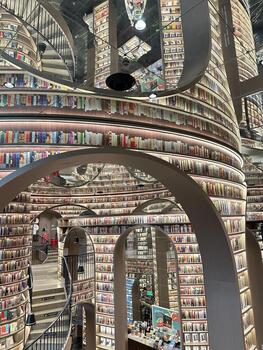 a spiral staircase inside a library with books on shelves photo