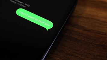 närbild se av en smartphone skärm som visar ett utgående jag inte vilja till ont du ha sönder upp tema text meddelande i en grön bubbla som den skickar. video