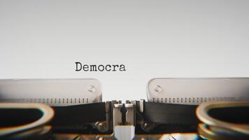 gammal mekanisk skrivmaskin skriver demokratisk uttryck i en stänga upp se, med metall brev slående de vit papper. video