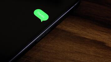närbild se av en smartphone skärm som visar ett utgående tack text meddelande i en grön bubbla, fångad som den skickar med en slät dyka upp animation. video