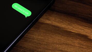 närbild se av en smartphone skärm som visar ett utgående vi behöver till prata text meddelande i en grön bubbla, fångad som den skickar med en slät dyka upp animation. video