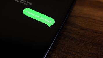 närbild se av en smartphone skärm som visar ett utgående snälla du ring upp mig tillbaka, dess brådskande text meddelande i en grön bubbla, fångad som den skickar. video