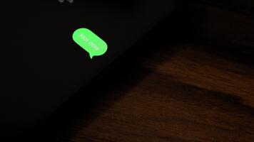 detailopname visie van een smartphone scherm tonen een uitgaand niet nu tekst bericht in een groen bubbel, gevangen genomen net zo het stuurt met een glad pop-up animatie. video