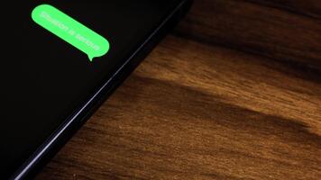 närbild se av en smartphone skärm som visar ett utgående situation är serios text meddelande i en grön bubbla, fångad som den skickar med en slät dyka upp animation. video