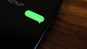 närbild se av en smartphone skärm som visar ett utgående jag är uthyrning gå text meddelande i en grön bubbla, fångad som den skickar med en slät dyka upp animation. video