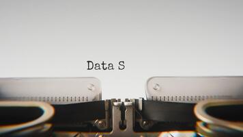 Old mechanical typewriter typing Data Security in a close up view, with metal letters striking the white paper. video