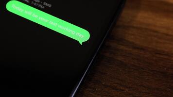 närbild se av en smartphone skärm som visar ett utgående i dag kommer vara din sista arbetssätt dag, hr kommer bearbeta din utgång, tack för din tid med oss video