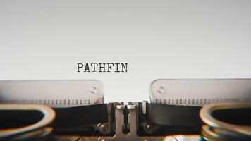 Old mechanical typewriter typing Pathfinder in a close up view, with metal letters striking the white paper. video