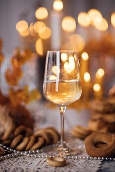 Elegant glass of sparkling wine sits on a beautifully arranged table with cookies and decorative elements, creating a warm and inviting atmosphere for celebrations photo