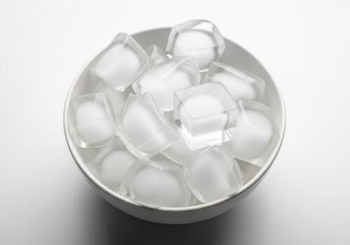 Bowl of clear ice cubes on a white background photo