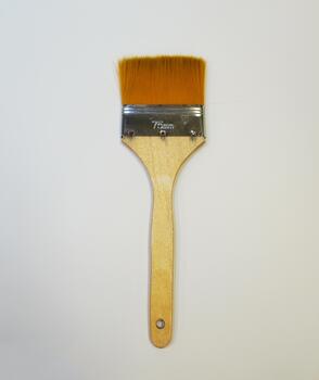 Flat paint brush on a white background. Wide bristles, wooden handle, 75 mm size, insulated object. photo