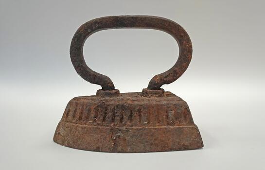 Antique cast iron with oval handle, rust and metal texture. White background, studio shooting, everyday objects of the past. photo