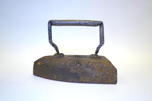 Antique rusty cast iron with a straight handle on a white background. Everyday objects of the past, studio photography, the texture of corrosion. photo