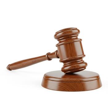 A wooden judges gavel resting on its base, isolated on white background photo