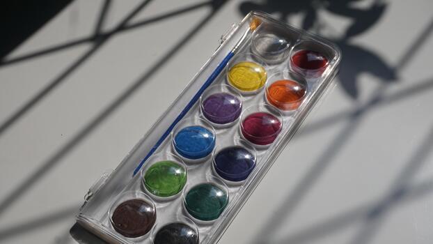 A set of multi-colored paints in a box on a white background photo