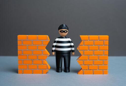 A criminal finds a hole in the wall. A breach in security. The threat of data theft and cybersecurity. System vulnerability and unauthorized access. Hacking risks, corporate espionage photo