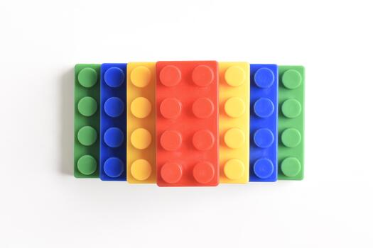Colorful interlocking building blocks arranged in a row on a white background. photo