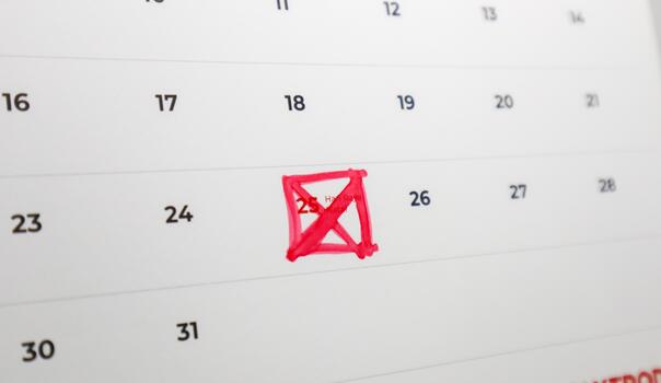 A close-up of a calendar page with the number 25 crossed out with a red marker. Other dates are visible around it, but the focus is on the marked date. photo