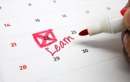 Circling an important Learn event on a calendar with a red marker, signifying a scheduled milestone for personal development and educational pursuits photo