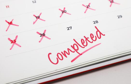 Calendar showing multiple crossed out dates and the word Completed in red, symbolizing task accomplishment and successful project wrap up photo