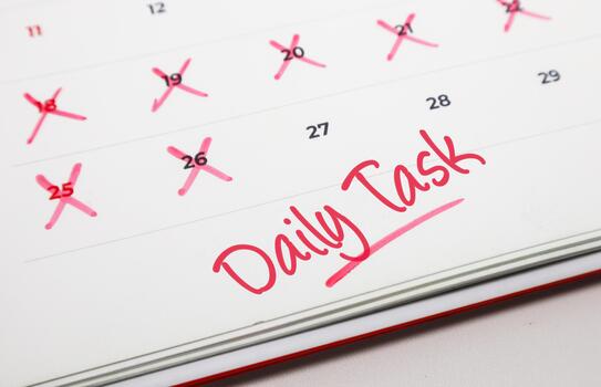 Daily Task written on a calendar page with dates marked as completed, symbolizing diligent management and a commitment to productivity photo