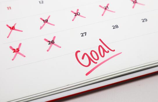 Calendar with crossed out dates and Goal written in red, symbolizing progress tracking towards a desired objective or target photo