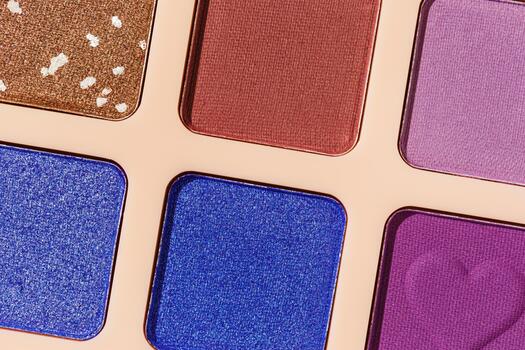 Close up minimal pattern with colorful eye shadow samples, trend color swatches on beige background. Eyeshadows powder with glitters for makeup, shiny and matte, aesthetic photo, top view photo