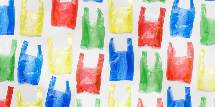 Top view pattern from colored plastic bags, wide banner. Single-use empty polythene packet, Eco trend to reduce disposable plastics, Biodegradable packaging waste, creative pattern, design photo