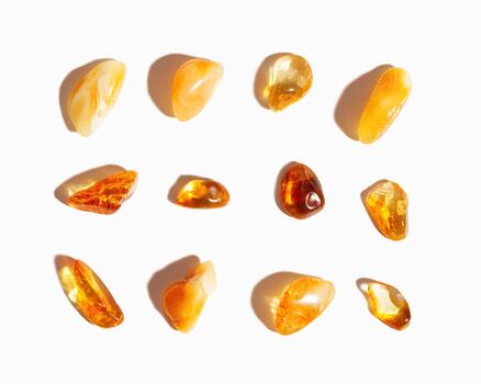 Set of Natural gemstone amber stones with glare shadows, yellow orange isolated on white background. Natural mineral Transparent amber gems different forms, flat lay pattern, minimal top view photo