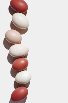 Easter eggs red gradient color, easter minimal trend background, shadow at sunlight, light backdrop. Chicken eggs colored eggshells, holiday food Easter, top view, aesthetic flat lay, vertical photo