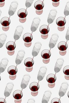 Minimal summer pattern with glasses of red wine, sunlight shadow on white background. Wine glasses flat lay, alcohol drinks modern photo. Holidays, parties, events, drink concept. Top view photo