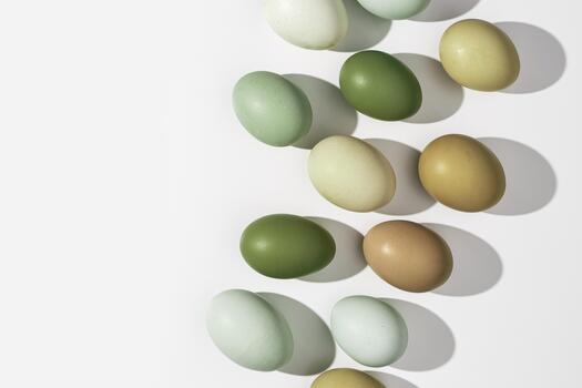 Natural Colorful Easter eggs close up, shadow at sunlight, white light background, copy space. Chicken eggs with nature colored eggshells, food Easter concept, top view, aesthetic flat lay photo