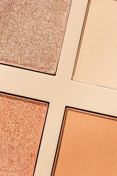 Top view textured pattern with different eyeshadow swatches, multi colors palette in beige plastic package. Close up eyeshadows powder for makeup, cosmetics texture design, beauty background photo