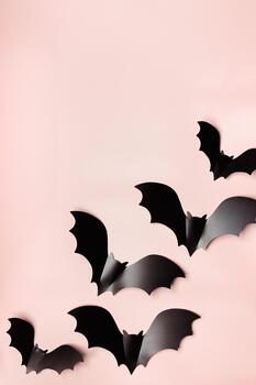 Minimal flat lay with black bats as halloween party background. Frame from paper decorations flying bats on beige background for holiday card. Aesthetic halloween pattern, copy space photo