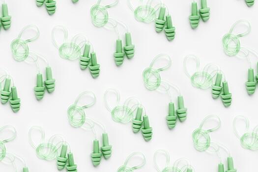Reusable silicone green earplugs, for swim, sleep, rest as minimal trend pattern on white background. Soft, flexible ear plug on cord against noise, protect hear, top view, flat lay photo