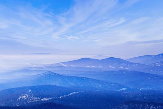 Aerial view of mountain ridges in soft fog. Beautiful white blue Peaks fades into distance. Minimal Nature abstract landscape, natural gradient color, environment winter serenity, panoramic skyline. photo