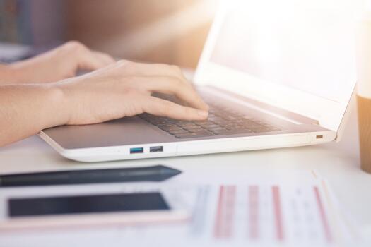 Woman hands typing on lap top keyboard, smart phone, paper, document, notebook on white table on office, faceless shot of female working online and using wireless Internet. Modern technology concept. photo