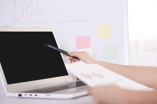 Technology, internet and home concept. Close up faceless portrait of female pointing with stylus to black blank screen of portable computer. Programmer or designer working online and using notebook. photo
