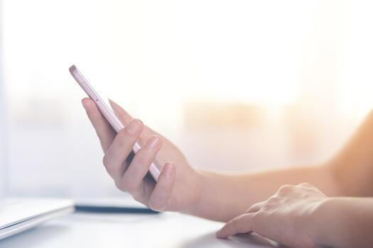 Side view of hand touching phone isolated over white backgrounde, guy sitting at table and holding his modern smart phone for online working, using wireless Internet. Modern technology concept. photo