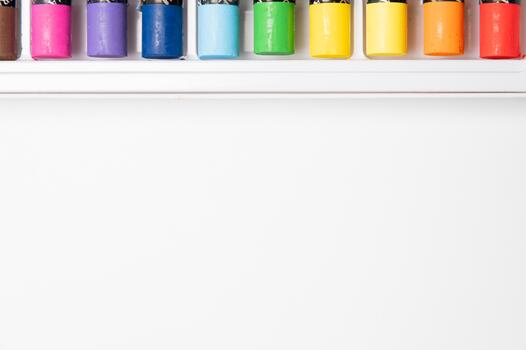 Sketchbook and multicolored pastels on a white table with a sheet of paper. Copy space. Close-up of an art stationery set photo