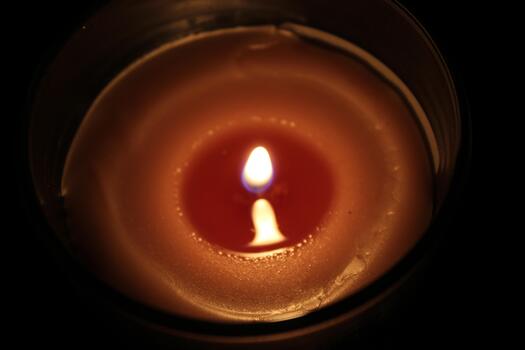 Flickering candlelight casts a warm glow in a darkened room, creating a calming atmosphere in the evening photo