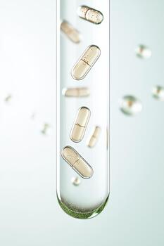 Tiny capsules suspended within a clear tube with small bubbles, representing molecular science and medical innovation. photo
