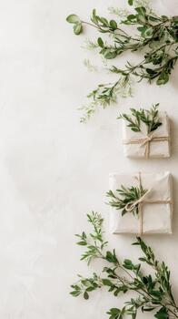 dos sencillo envuelto regalos atado con enroscarse y decorado con Fresco verde hojas en un texturizado neutral antecedentes. foto