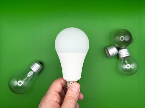 Modern LED lamp. Tungsten light bulb lamp. Non-working light bulb, broken light bulb. Concept of light and dark, idea, electricity copy space, flay lay, green background photo