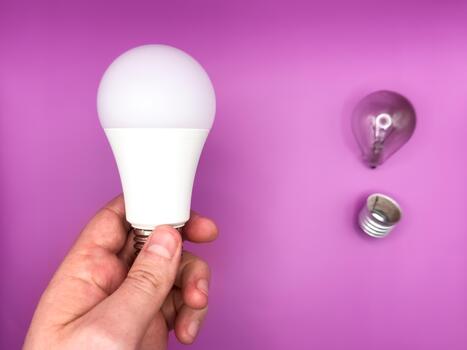 Modern LED lamp, saving electricity light bulb lamp. Non-working light bulb, broken light bulb. Concept of light and dark, idea, electricity copy space, flay lay, top view purple background. photo