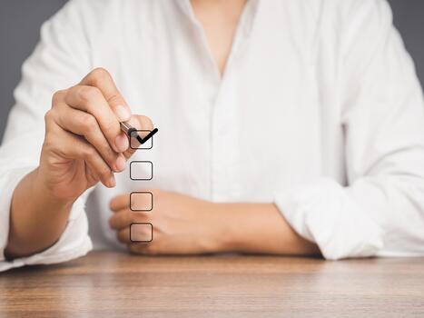 Close-up of business people use a pen to tick the correct sign mark in the checkbox while sitting at the table. photo