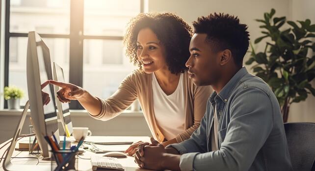 Diverse colleagues working together in a modern office, collaborating on a project, showcasing teamwork and productivity, at computers photo