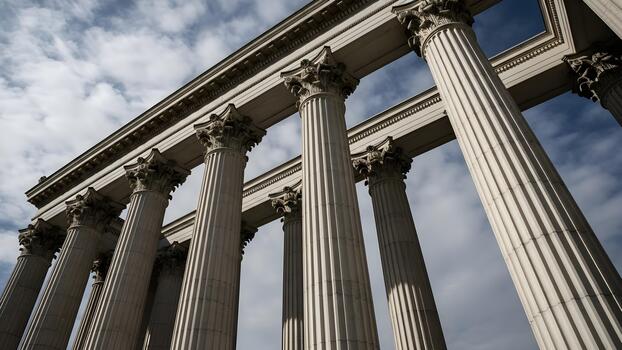 Low angle view of classical columns against a cloudy sky photo