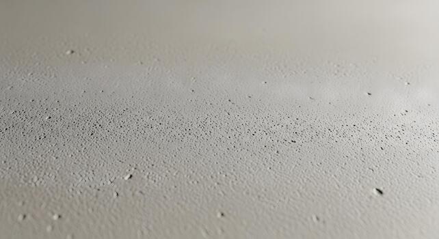 Abstract close-up of tiny water droplets on a smooth, light-colored surface, creating a subtle texture and pattern photo