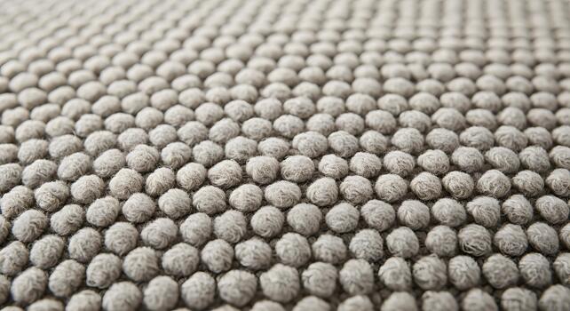 Close-up macro view of a textured woven fabric surface with a repeating pattern of soft, rounded fibers creating a tactile background photo